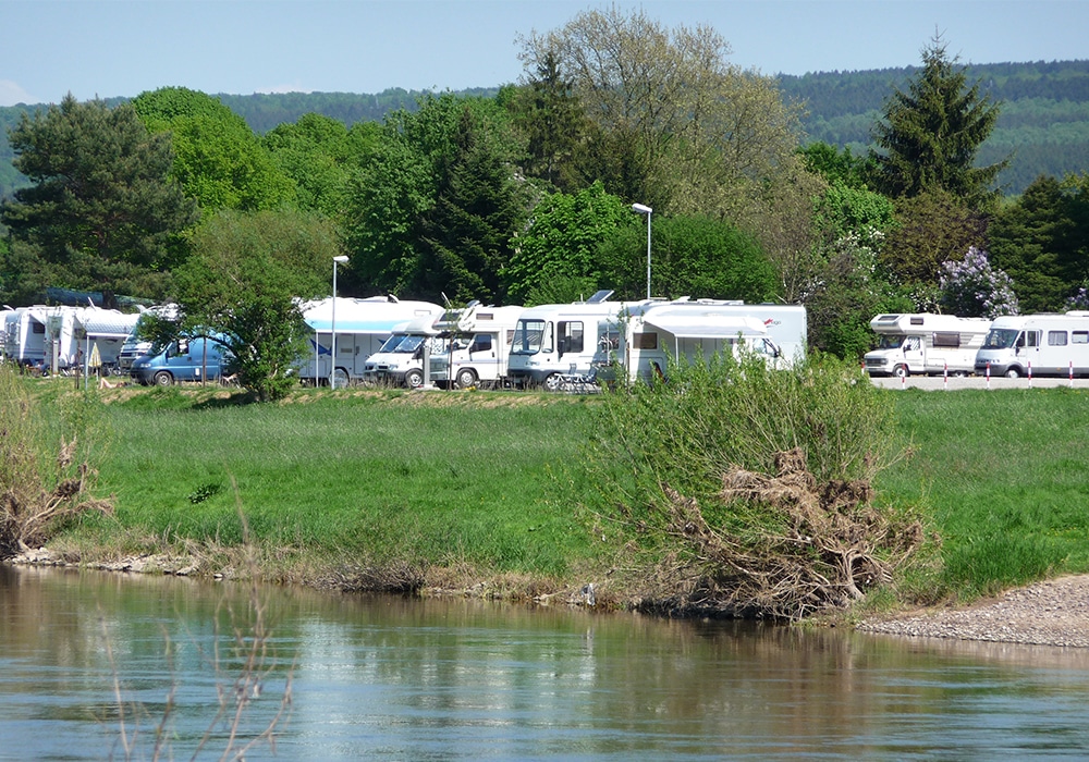 Stellplatz mit Wohnmobilen am Ufer der Weser in Höxter.